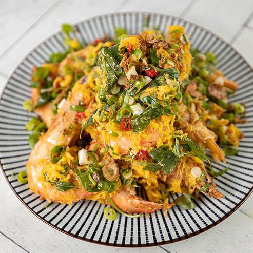 Striped bowl of Malay Prawns with spring onion and chilli