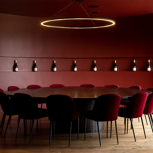Apex room with red wall and brown chairs around a round table
