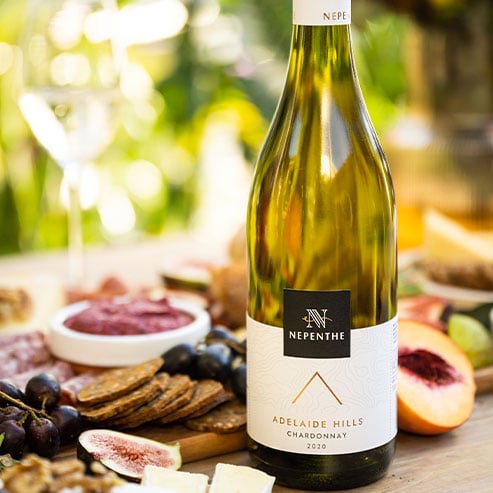 Bottle of Nepenthe Elevation Chardonnay outdoors with a charcuterie board